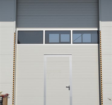 Detail průmyslových vrat s integrovanými dveřmi